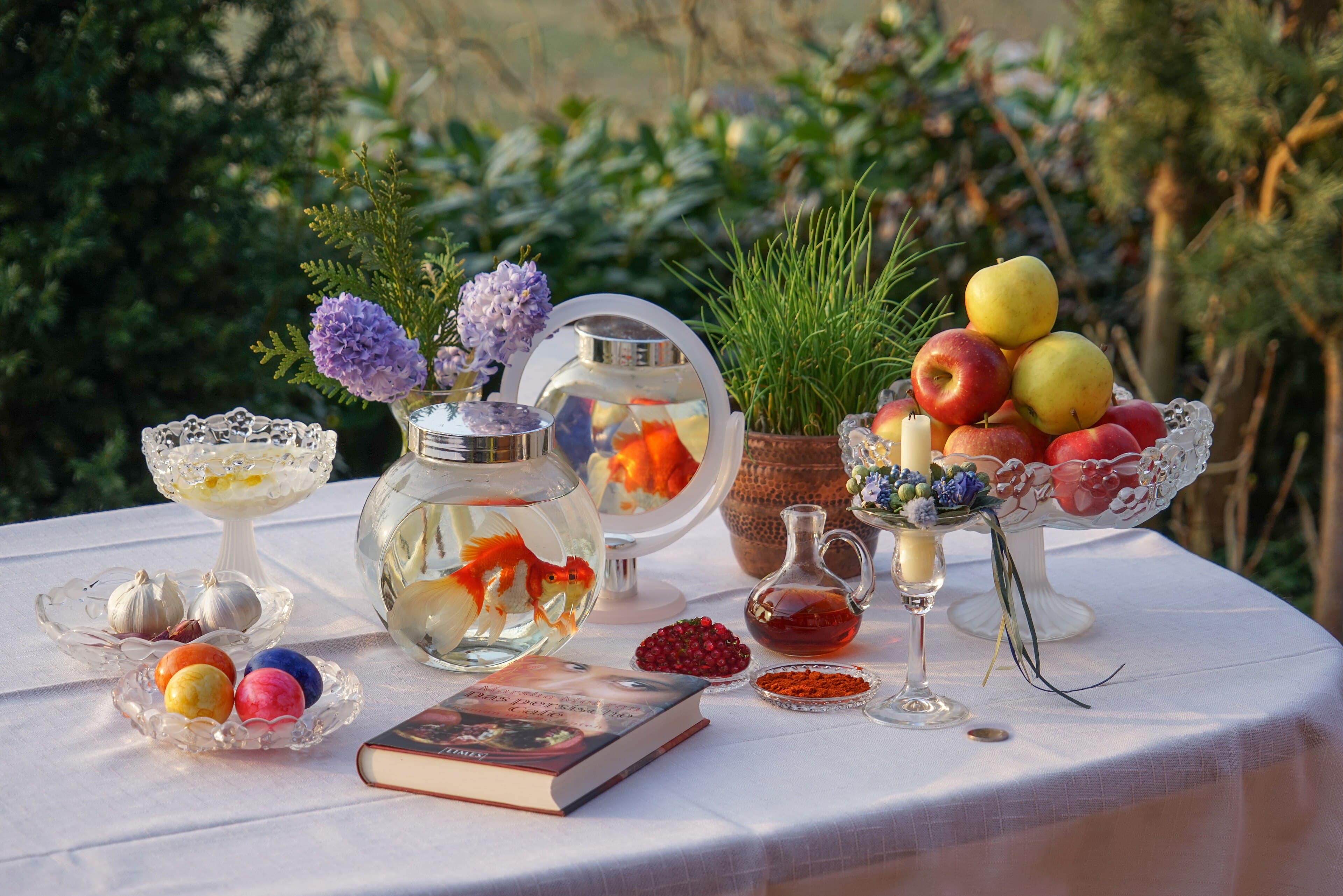 Families gathered in a park with colourful decorations and traditional sumalak dish for Navruz